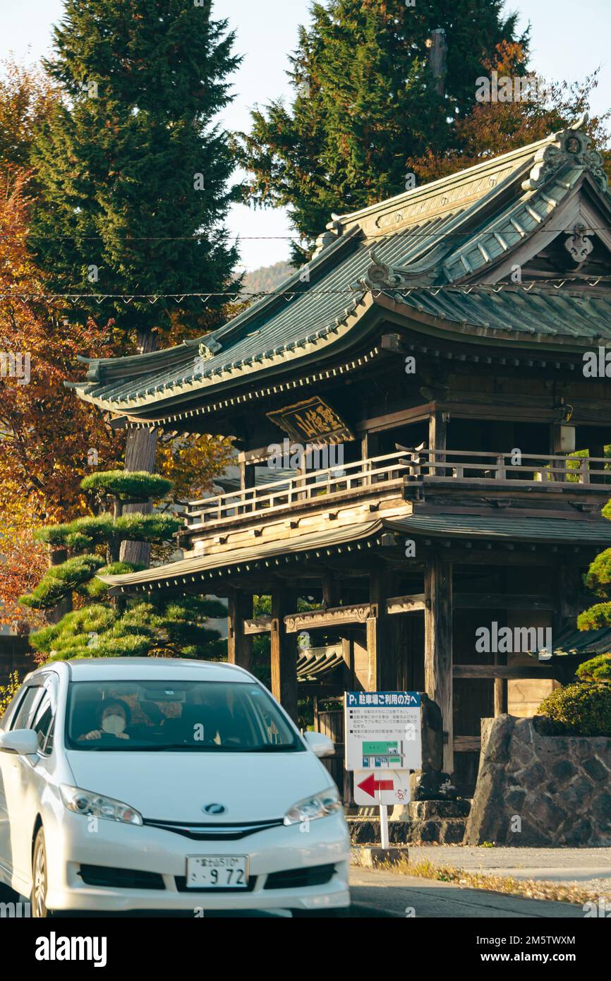 A car driving past an old japanese architecture Stock Photo