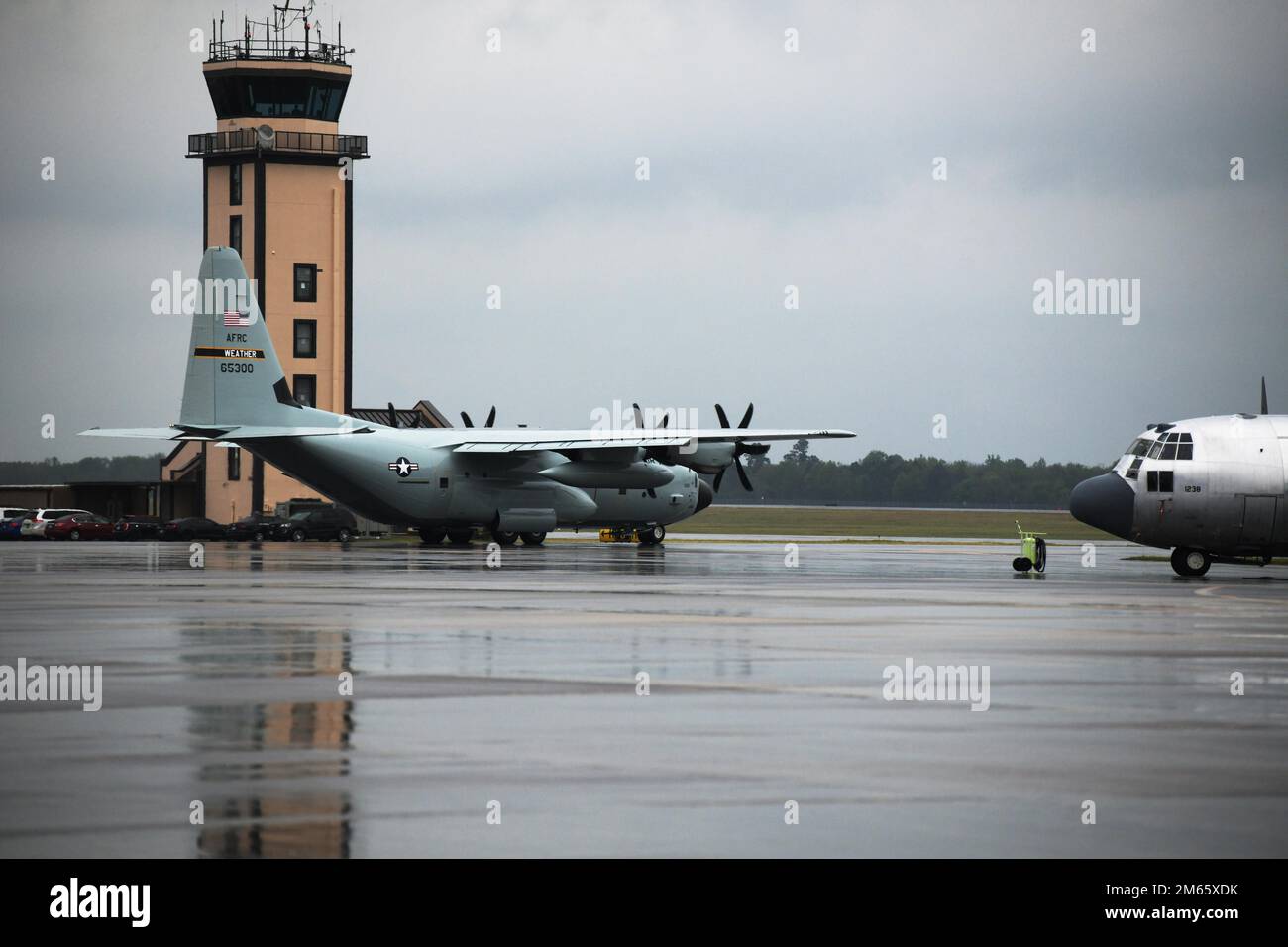 ROBINS AIR FORCE BASE, Ga. – The WC-130J aircraft from Keesler Air Force Base,  Mississippi, passes by the Air Traffic Control Tower at Robins Air Force Base, Georgia, April 5, 2022. The weather aircraft received depot level maintenance at the Warner Robins Air Logistics Complex and now dons a glossy gray paint scheme, which is a throwback to the original look of the weather aircraft prior to 2008. Stock Photo