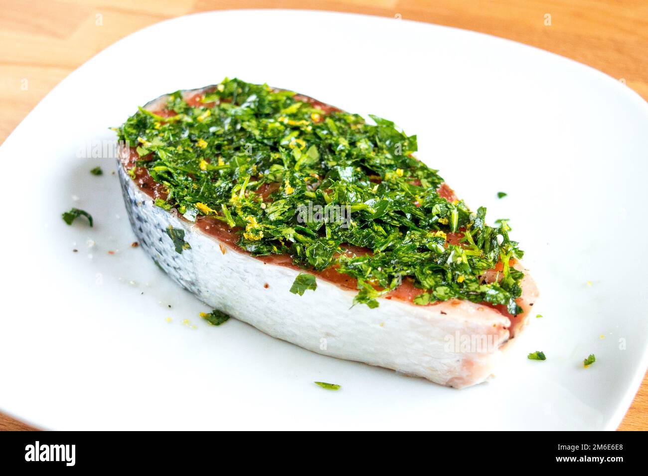 Raw salmon with salt, pepper and herbs. Red fish in marinade Stock Photo