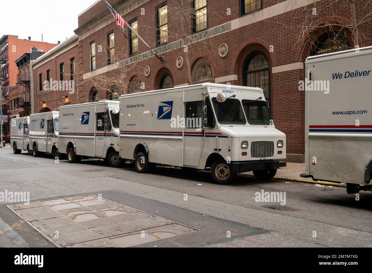 USPS vehicles in front of the Old Chelsea Station post office in New York on Monday, January 2, 2023. The USPS recently announced that it will have a fleet of over 66,000 electric vehicles by 2028. (© Richard B. Levine) Stock Photo