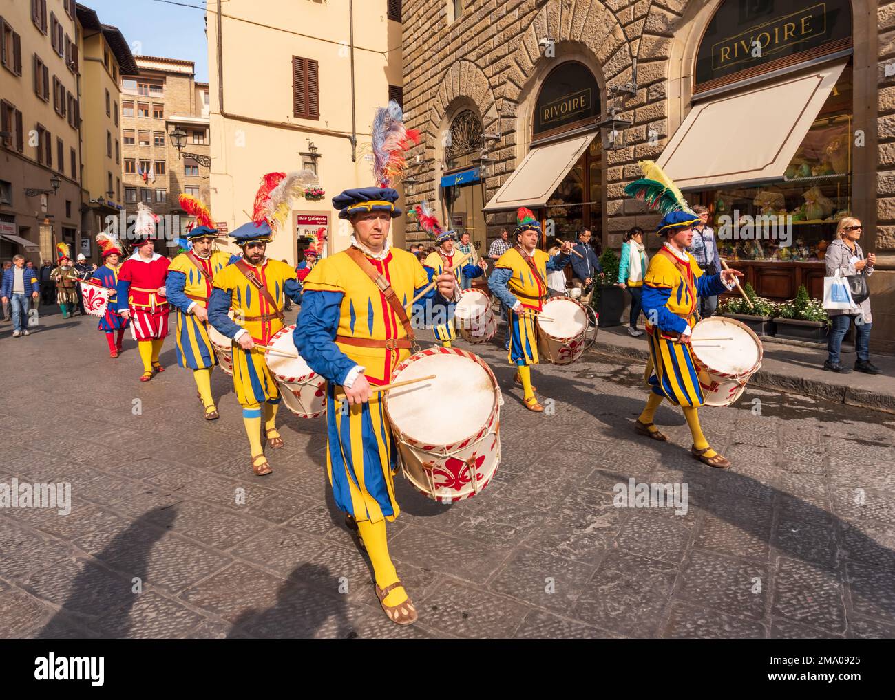 A parade of men dressed in period costumes march into the Piazza Della Signori while playing their drums decorated in the coat of arms of Florence Stock Photo