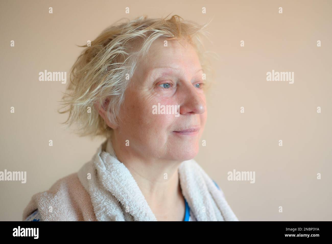 Aged woman with wet hair after bath. Stock Photo