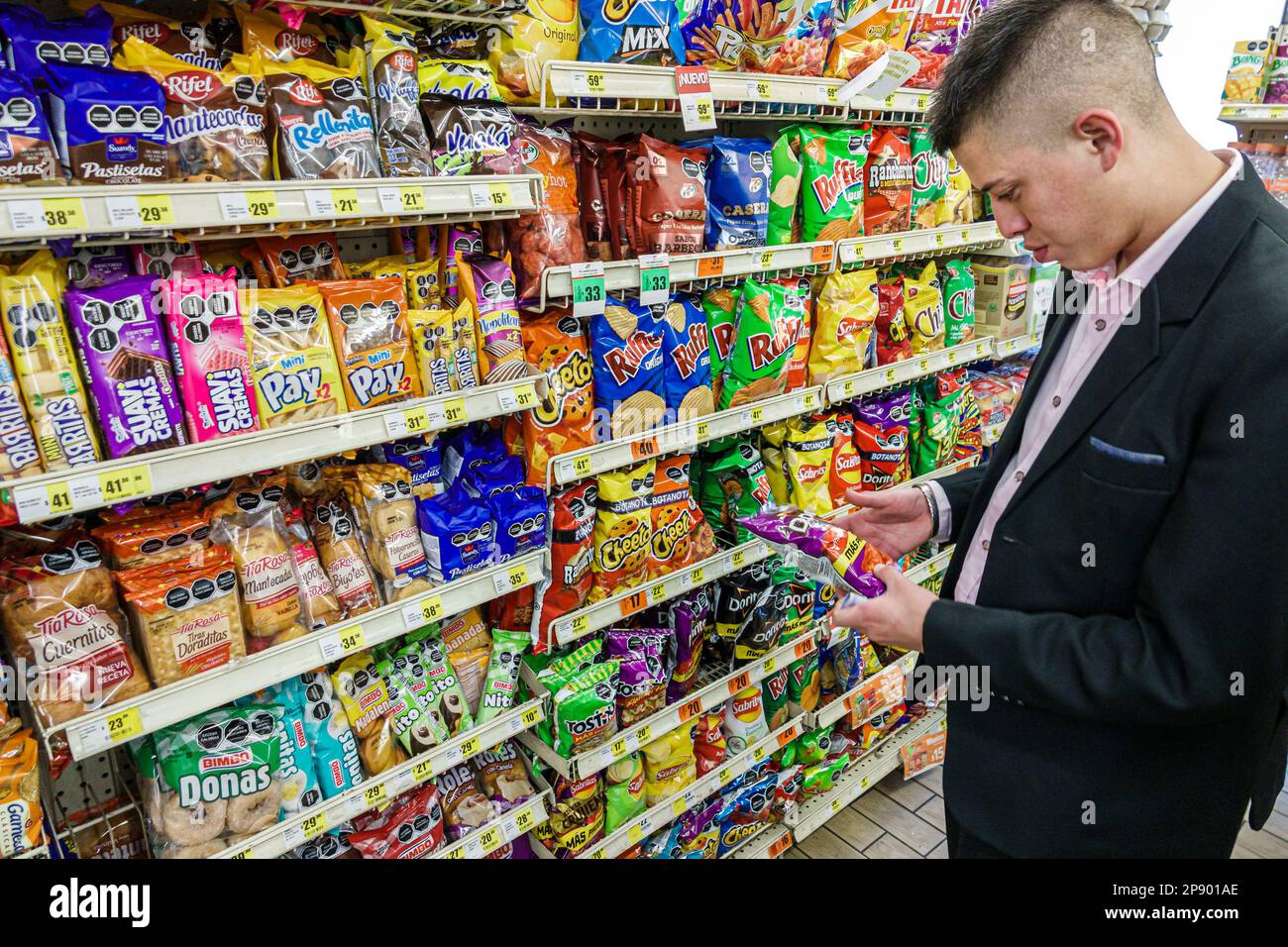 Mexico City,7-Eleven snacks snack junk food,Ruffles Cheetos,choosing looking at,man men male,adult adults,resident residents,inside interior indoors,c Stock Photo