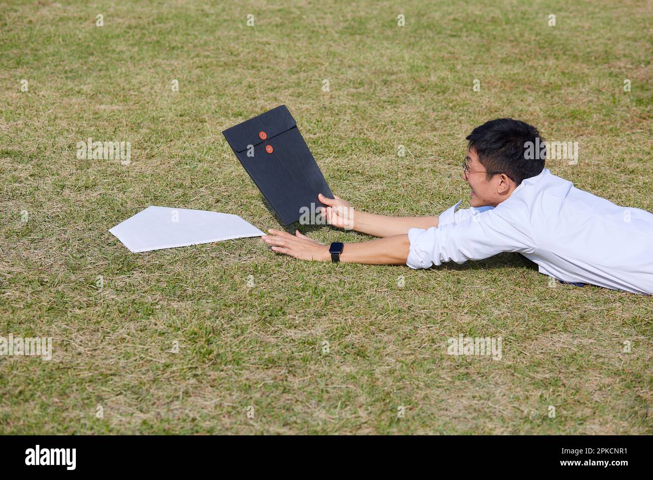 Man in suit with materials sliding into home base Stock Photo