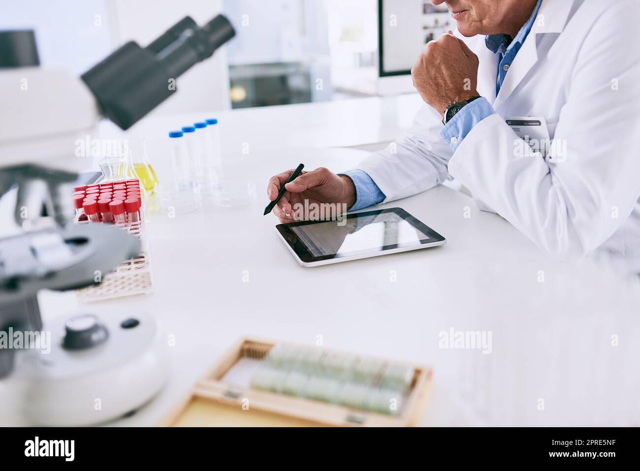 There are even apps to help test your theories. a mature scientist working on a digital tablet in a lab. Stock Photo