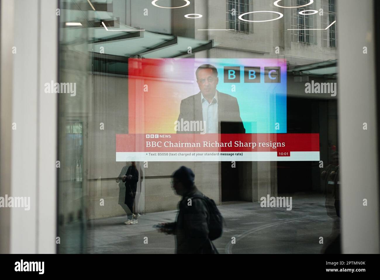 A screen showing a news report seen through the windows of the BBC in central London, after chairman Richard Sharp announced he was quitting as BBC chairman to 'prioritise the interests' of the broadcaster after a report by Adam Heppinstall found he breached the governance code for public appointments. Mr Sharp conceded after Adam Heppinstall KC's report into his appointment found he 'failed to disclose potential perceived conflicts of interest'. Picture date: Friday April 28, 2023. Stock Photo