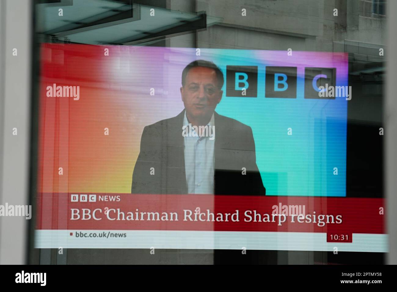 A screen showing a news report seen through the windows of the BBC in central London, after Richard Sharp announced he was quitting as BBC chairman to 'prioritise the interests' of the broadcaster after a report by Adam Heppinstall found he breached the governance code for public appointments. Mr Sharp conceded after Adam Heppinstall KC's report into his appointment found he 'failed to disclose potential perceived conflicts of interest'. Picture date: Friday April 28, 2023. Stock Photo