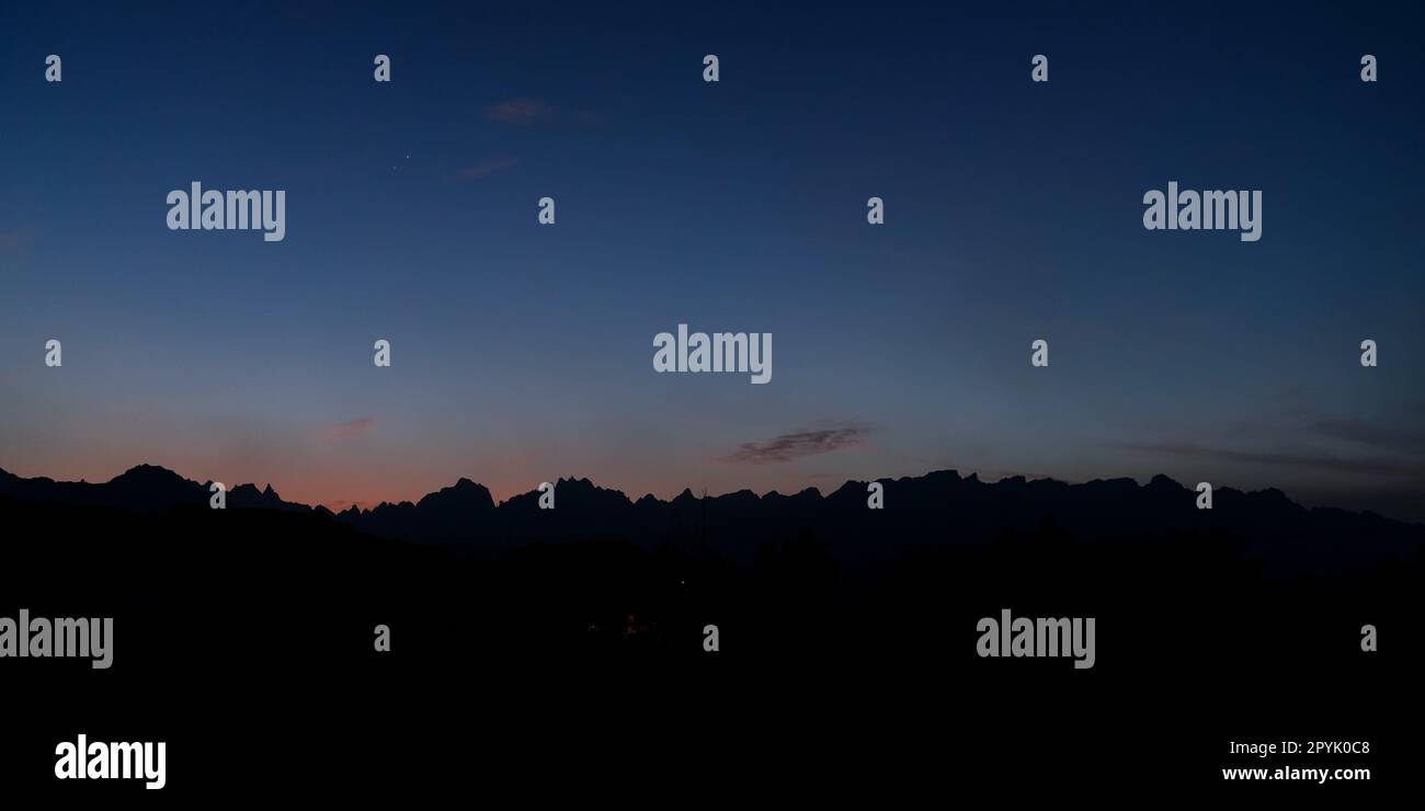 Silhouettes of low desert mountains with blue sky just after sunset - Venus and Jupiter visible - typical evening landscape near Yanbu, Saudi Arabia Stock Photo