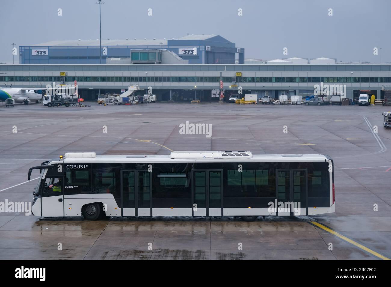 Empty white airport bus in a rainy day. Aviation service at Manchester Airport Stock Photo