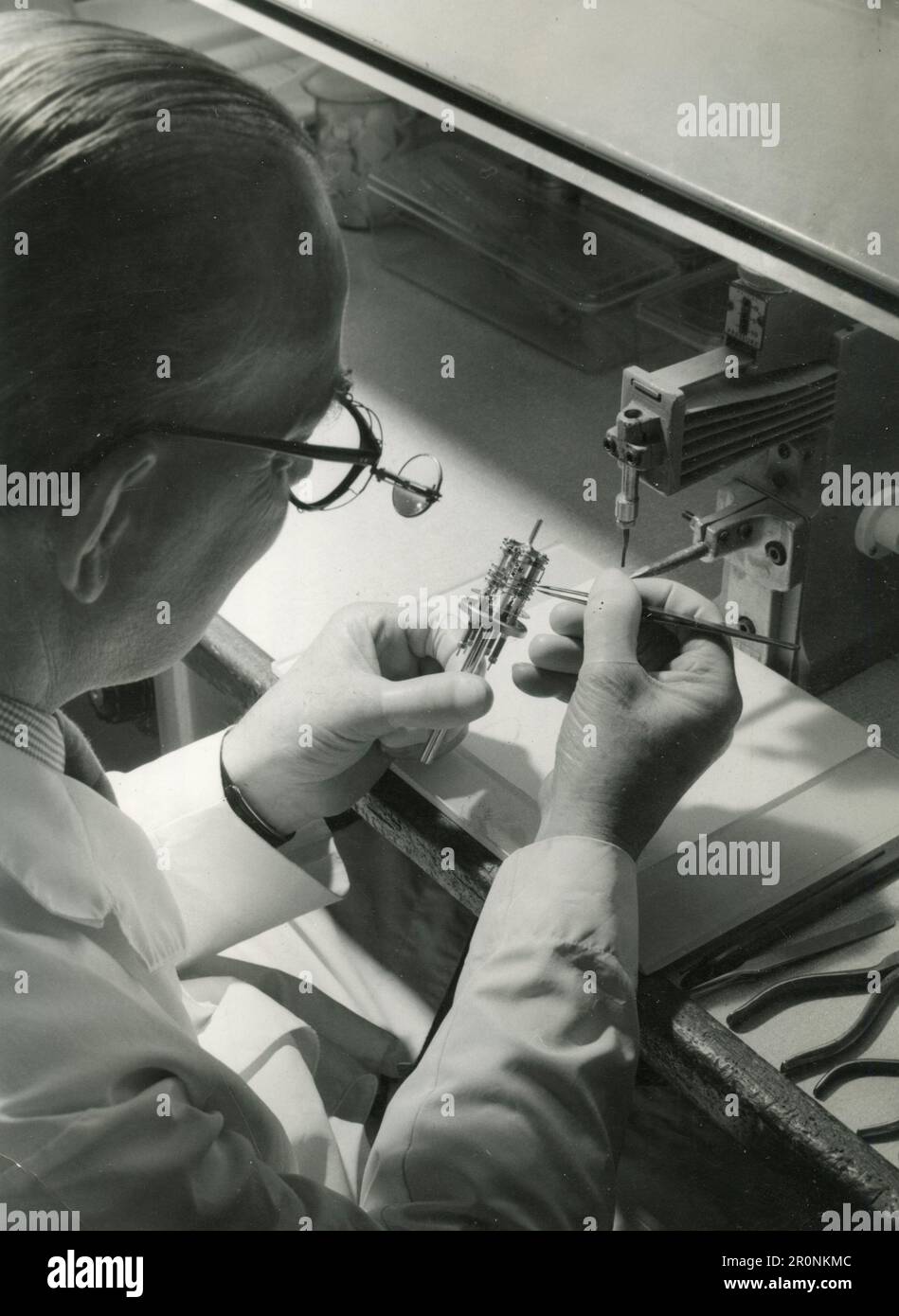 Technician alining the cathode with other electrodes of a travelling wave tube electron gun assembly, UK 1966 Stock Photo