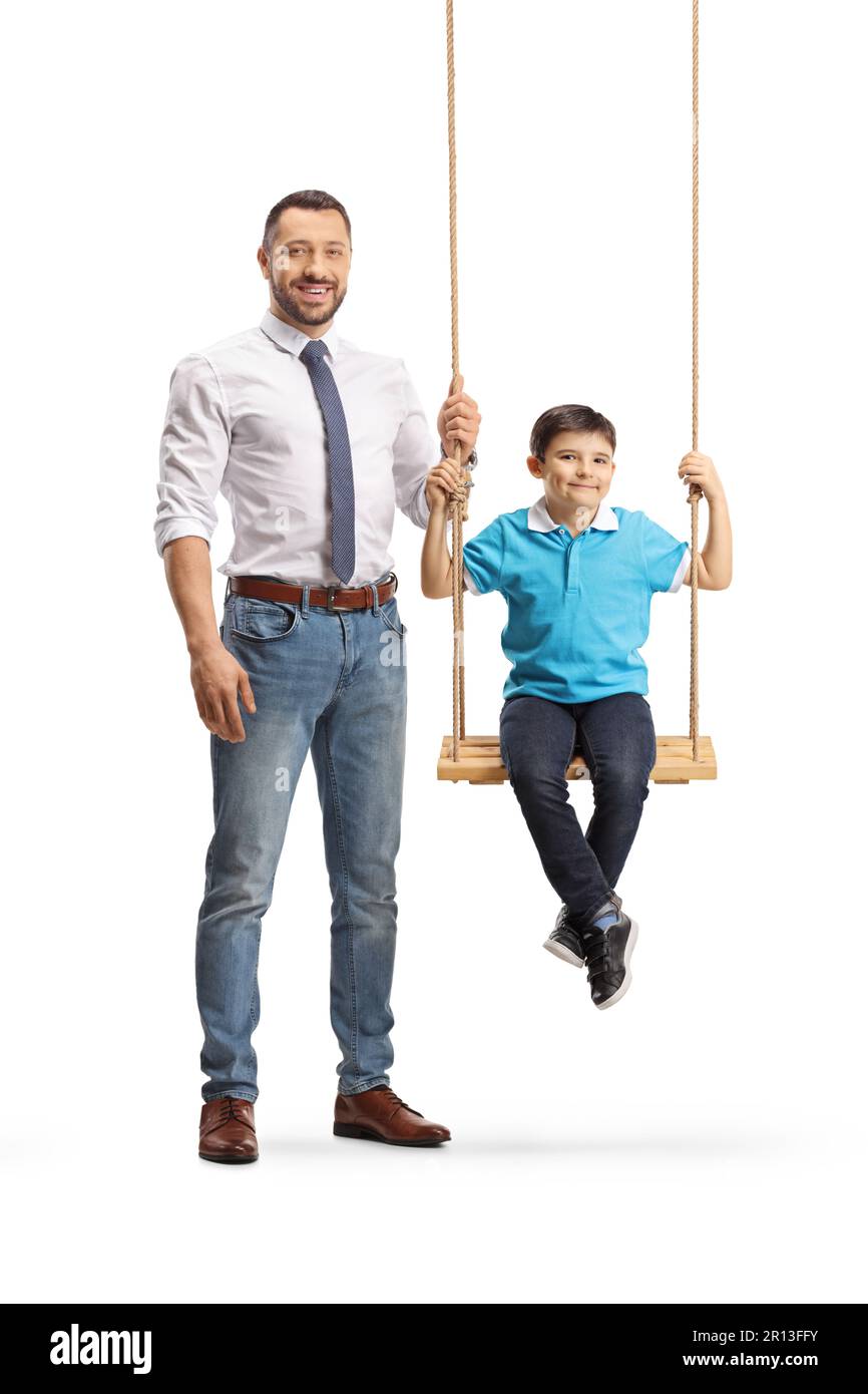 Full length portrait of a father standing nexto to a boy on a swing isolated on white background Stock Photo