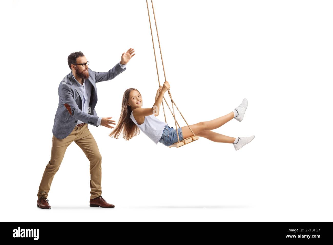 Full length shot of a father pushing a girl on a swing isolated on white background Stock Photo