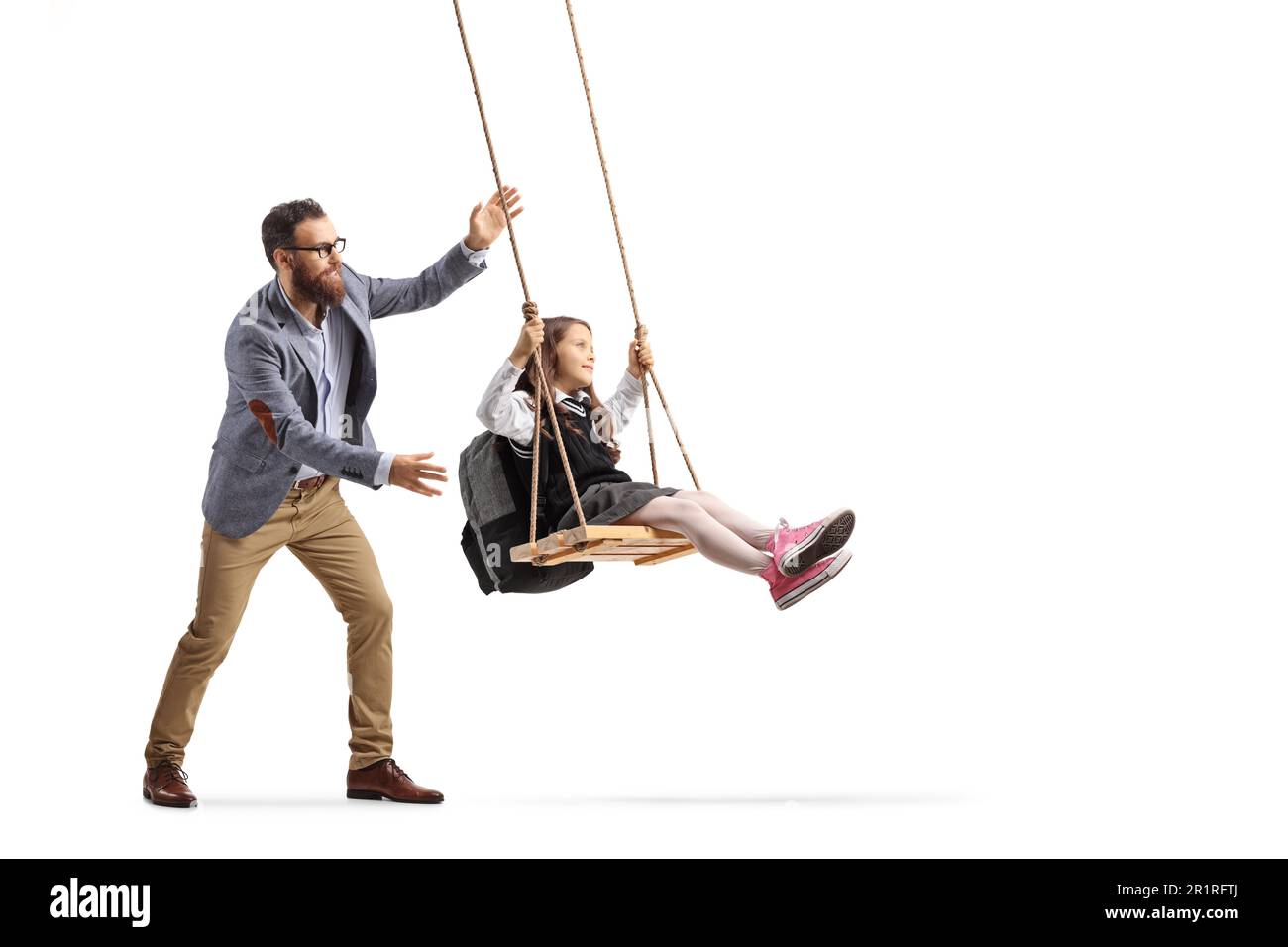 Full length shot of a man pushing a schoolgirl on a swing isolated on white background Stock Photo