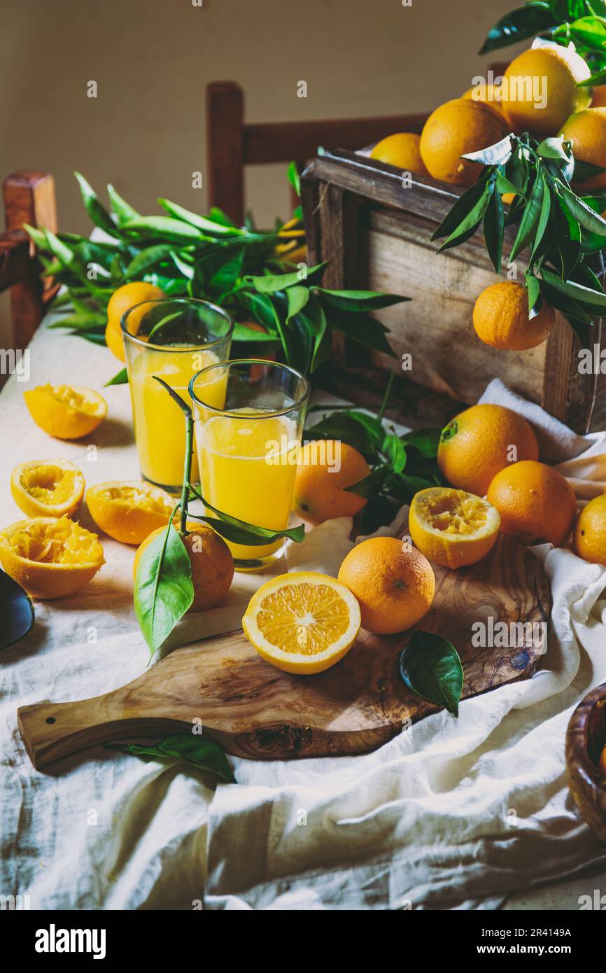 Table with box of fresh orange with orange tree branch and fresh orange juice Stock Photo