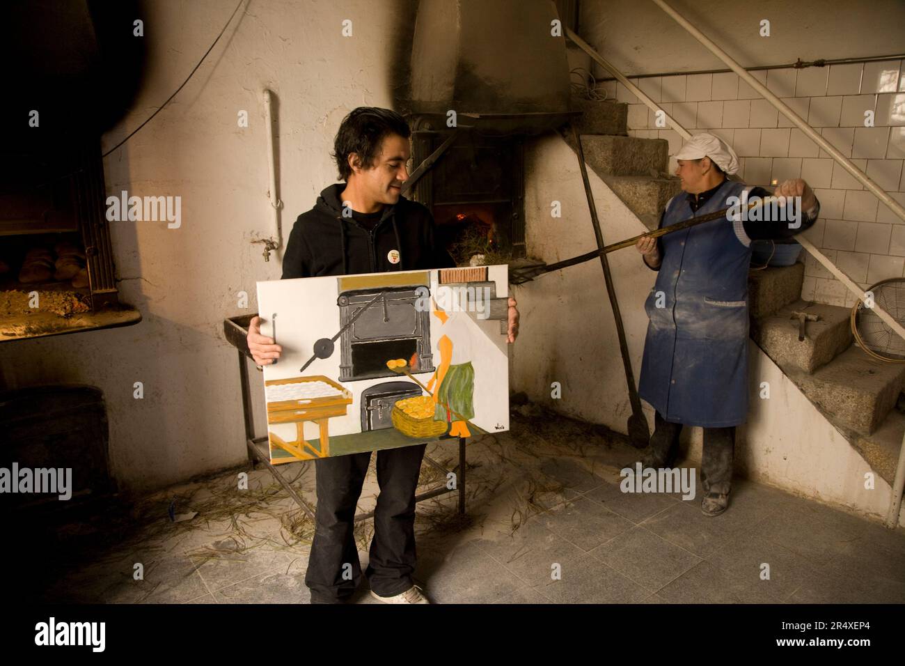 Baker displays a painting of bread baking in his bakery; Favaios, Douro River Valley, Portugal Stock Photo