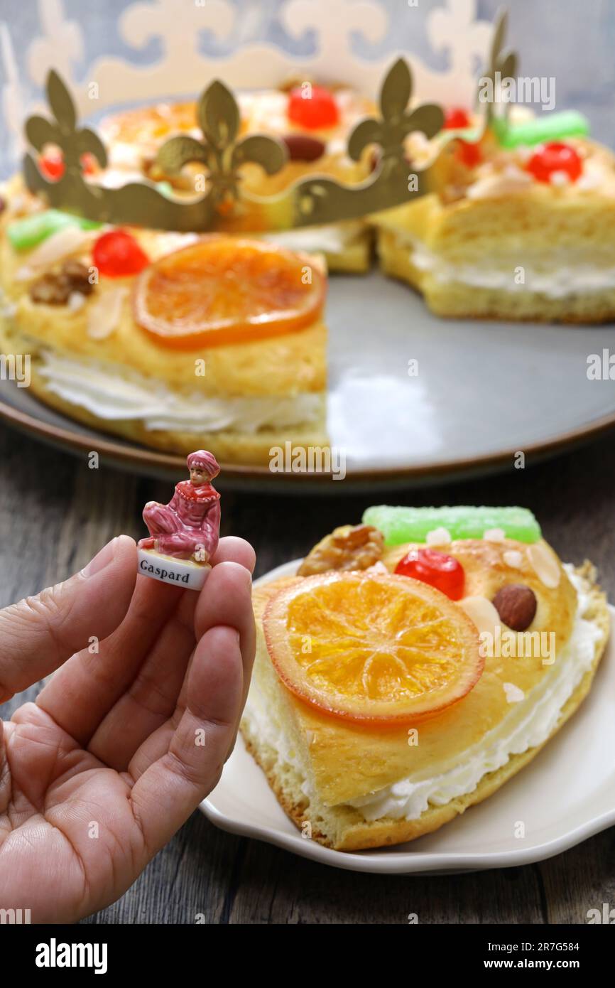 Roscón de reyes, Spanish King’s cake getting one figurine of the three wise men Biblical Magi from a king cake. Stock Photo