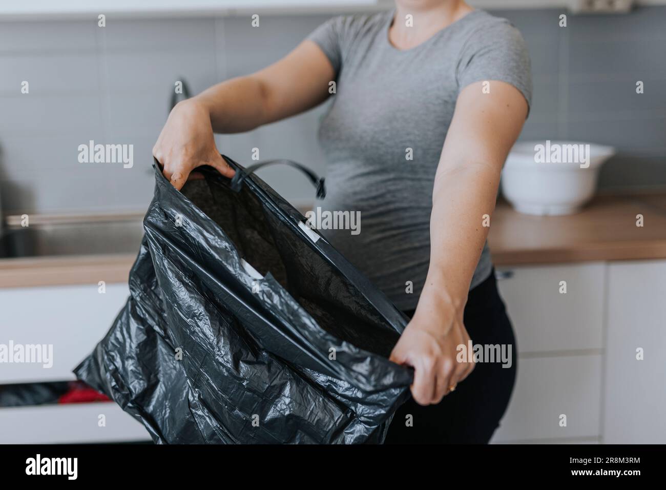 Mid section of woman holding trash bag Stock Photo