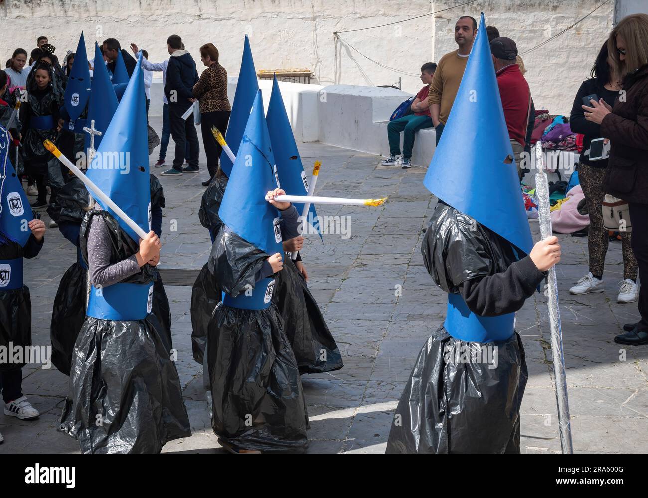 Kids with cloaks and hoods (Capirotes) at Holy Week Procession (Semana Santa) - Arcos de la Frontera, Cadiz, Spain Stock Photo