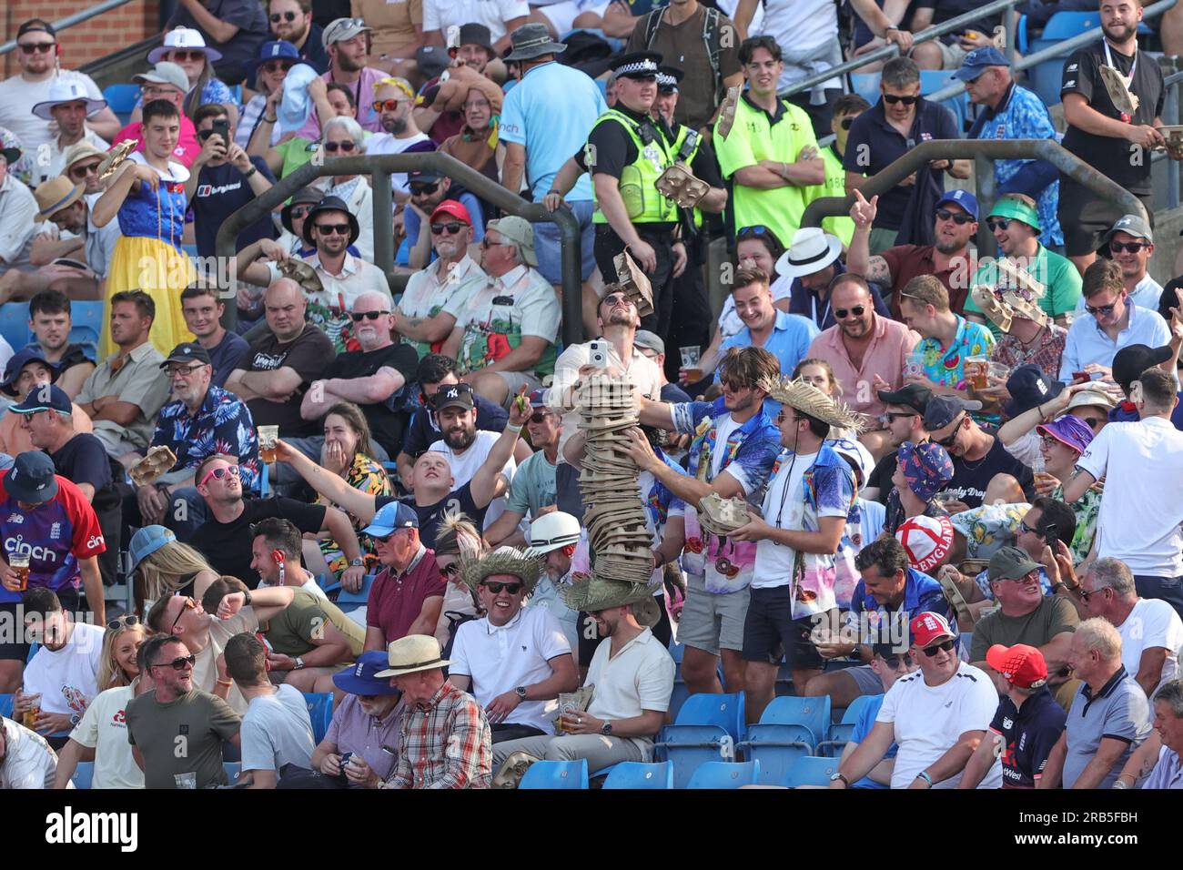 Fans messing about with drink holders in the stand during the LV= Insurance Ashes Third Test Series Day 2 England v Australia at Headingley Stadium, Leeds, United Kingdom, 7th July 2023  (Photo by Mark Cosgrove/News Images) Stock Photo