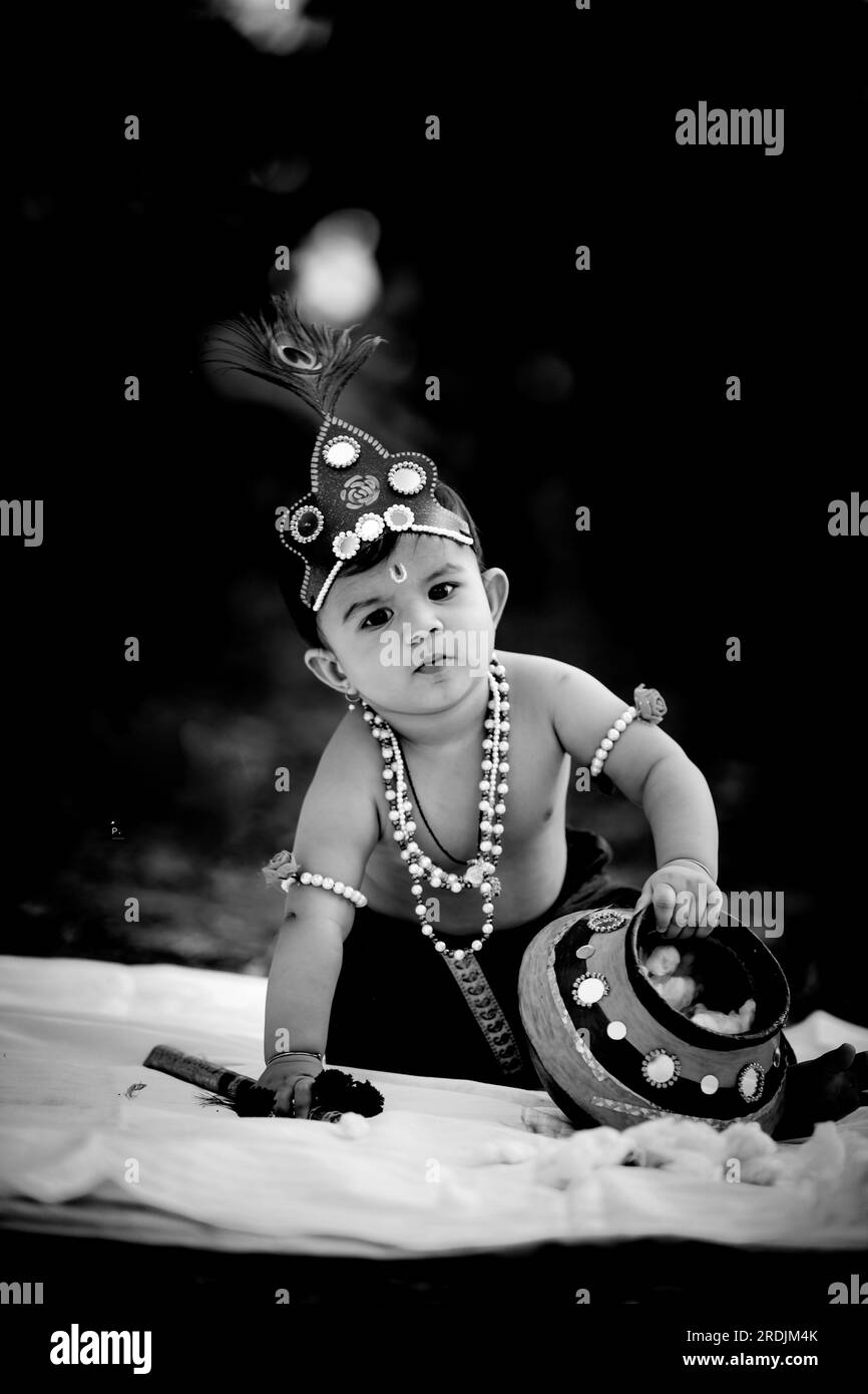 happy Janmashtami , Little Indian boy posing as Shri Krishna or kanha or kanhaiya with Dahi Handi picture Stock Photo