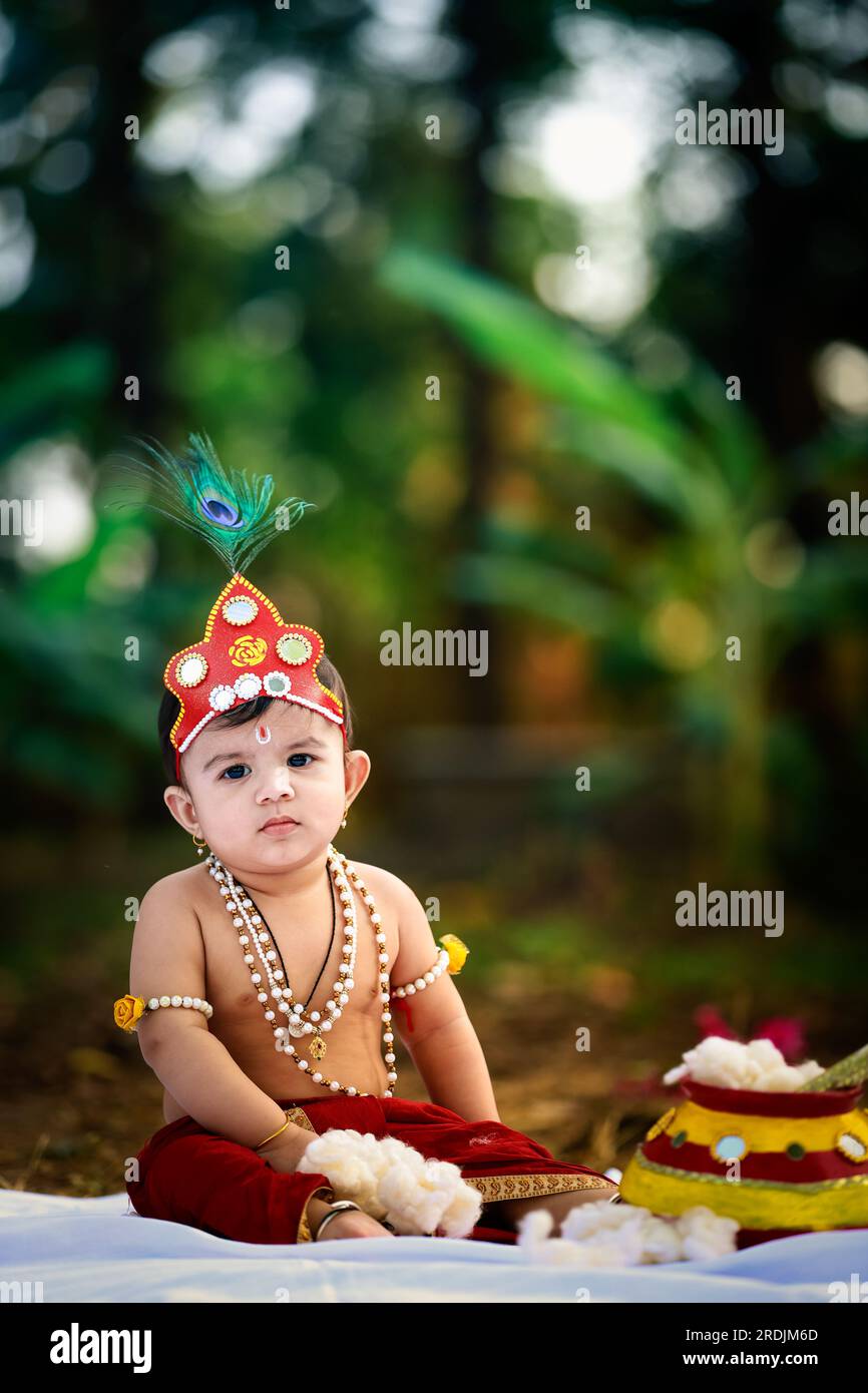 happy Janmashtami , Little Indian boy posing as Shri Krishna or kanha or kanhaiya with Dahi Handi picture Stock Photo