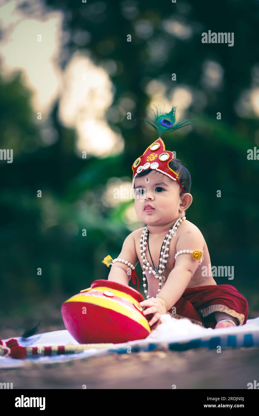 happy Janmashtami , Little Indian boy posing as Shri Krishna or kanha or kanhaiya with Dahi Handi picture Stock Photo