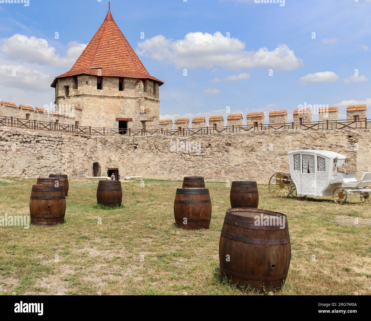 Inside the courtyard of a medieval castle with barrels and a beautiful horse carriage Stock Photo