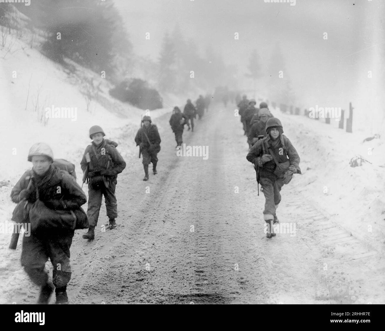 NEAR MURRINGEN, BELGIUM - 31 January 1945 -- US Army troops of the 1st Division march through snow towards Murringen, Belgium, after a major German co Stock Photo