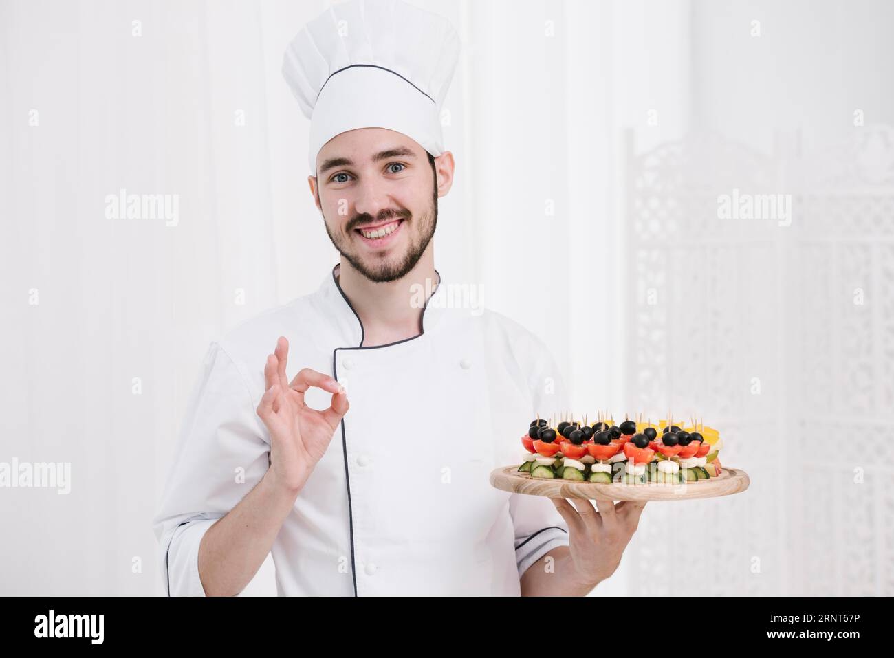 Smiley chef with hat holding plate Stock Photo