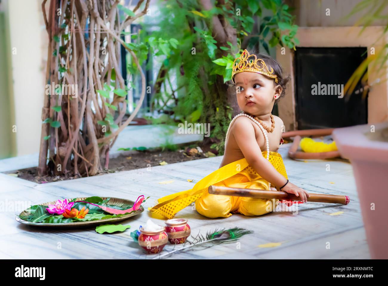 adorable infant dressed as hindu god krishna cute facial expression with flute at janmashtami Stock Photo