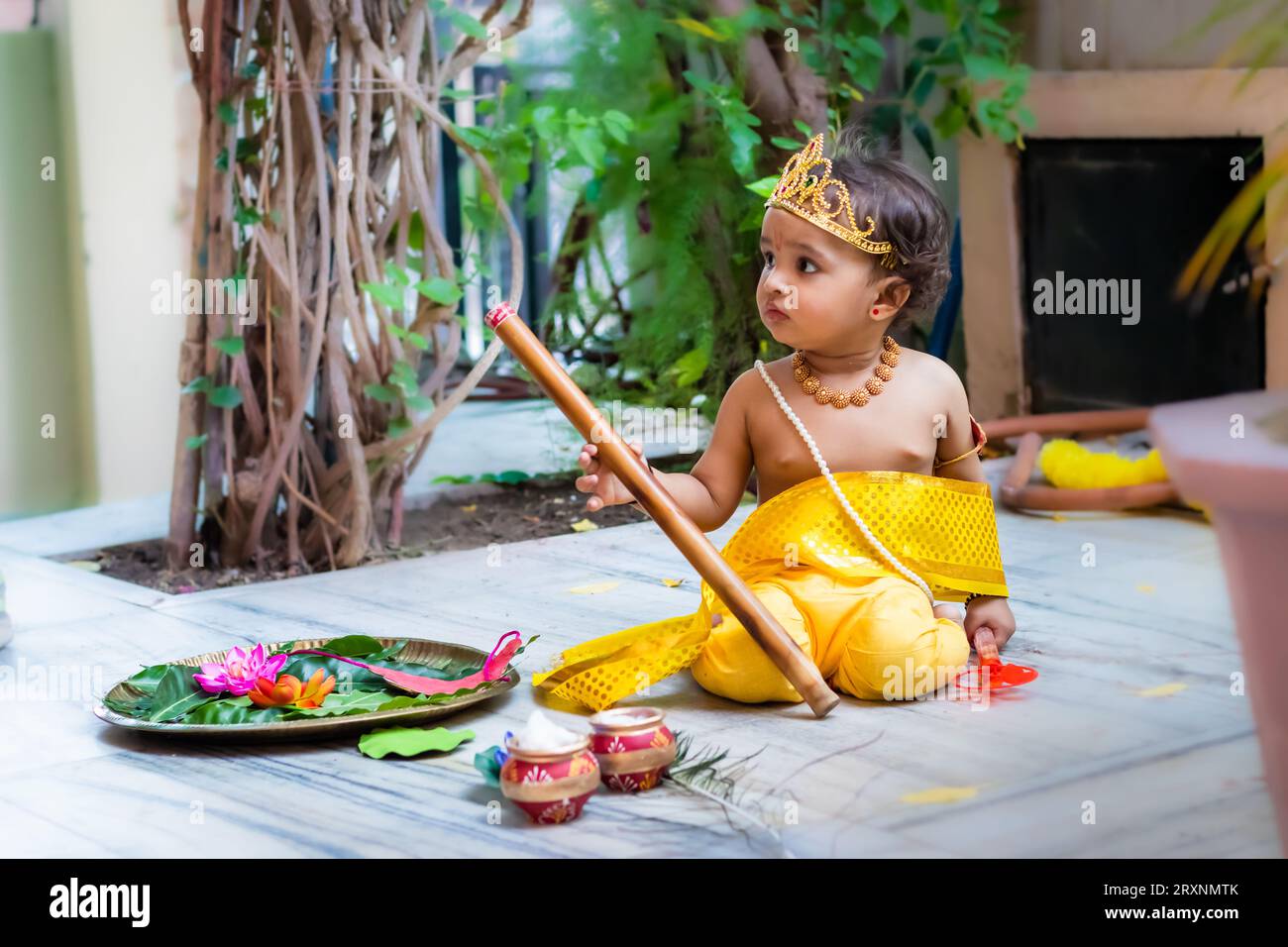 adorable infant dressed as hindu god krishna cute facial expression with flute at janmashtami Stock Photo