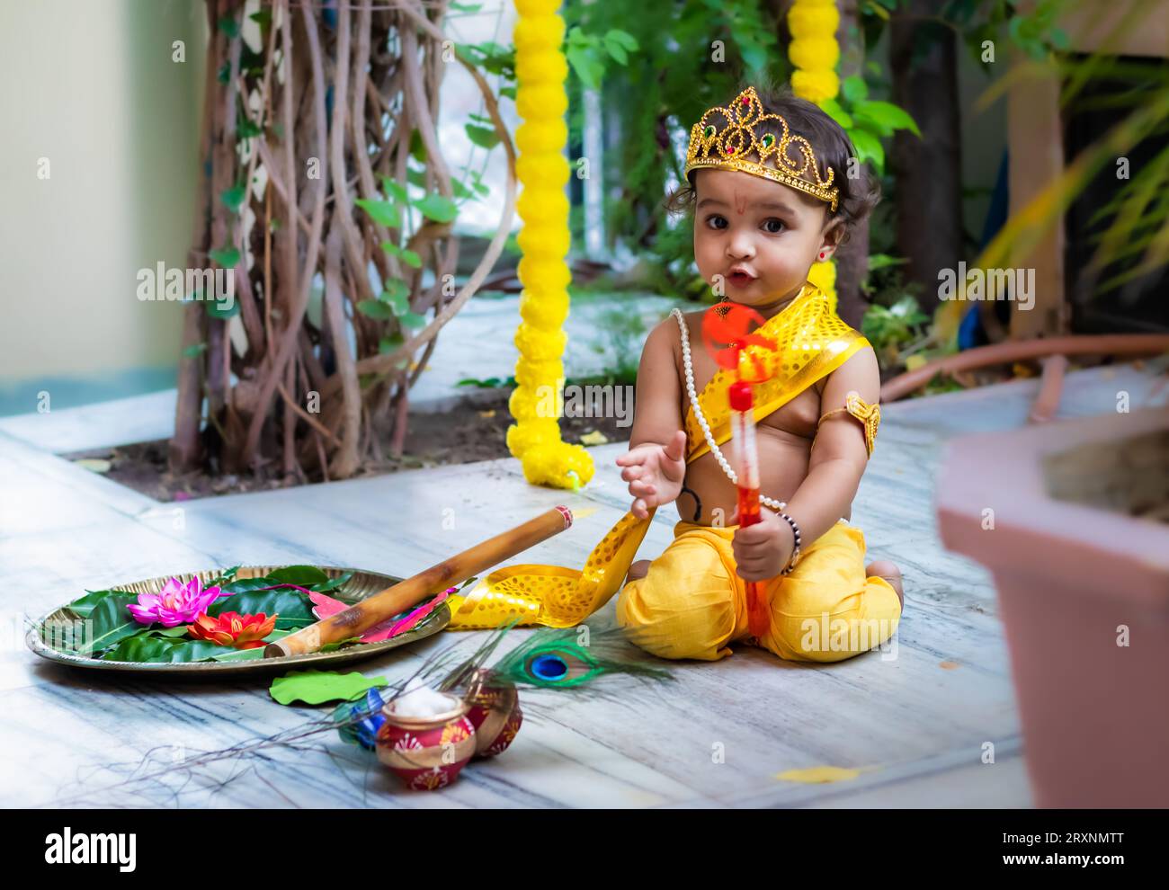 adorable infant dressed as hindu god krishna cute facial expression with flute at janmashtami Stock Photo