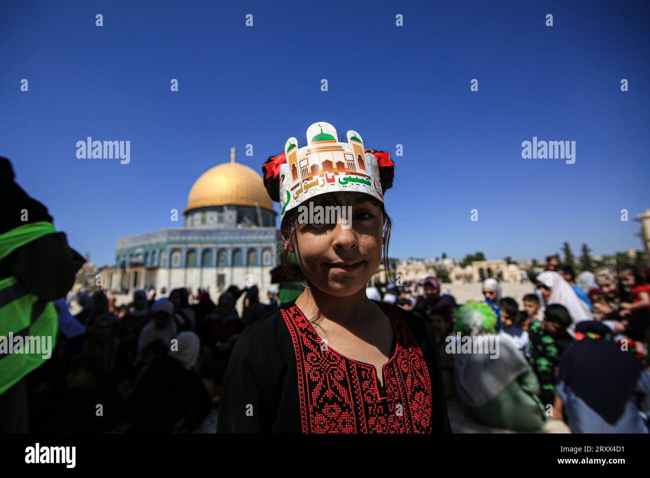 A Palestinian girl looks on during the gather to commemorate the birth of the Prophet Muhammad, known in Arabic as “Mawlid al-Nabawi,” outside the Dome of the Rock in the Al-Aqsa Mosque complex, Islam’s third holiest site, in the Old City of Jerusalem. Stock Photo