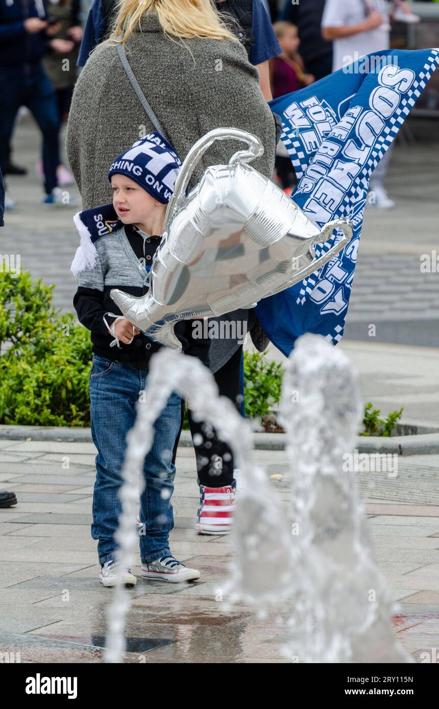 Southend United celebrated promotion to League One with an open top bus parade through the town and along the seafront. Young fan with cup balloon Stock Photo