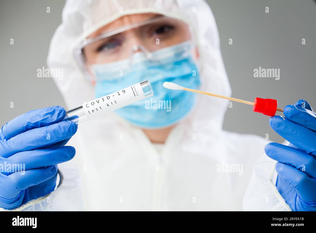 Female doctor in coveralls holding COVID-19 PCR nasal swabbing kit Stock Photo