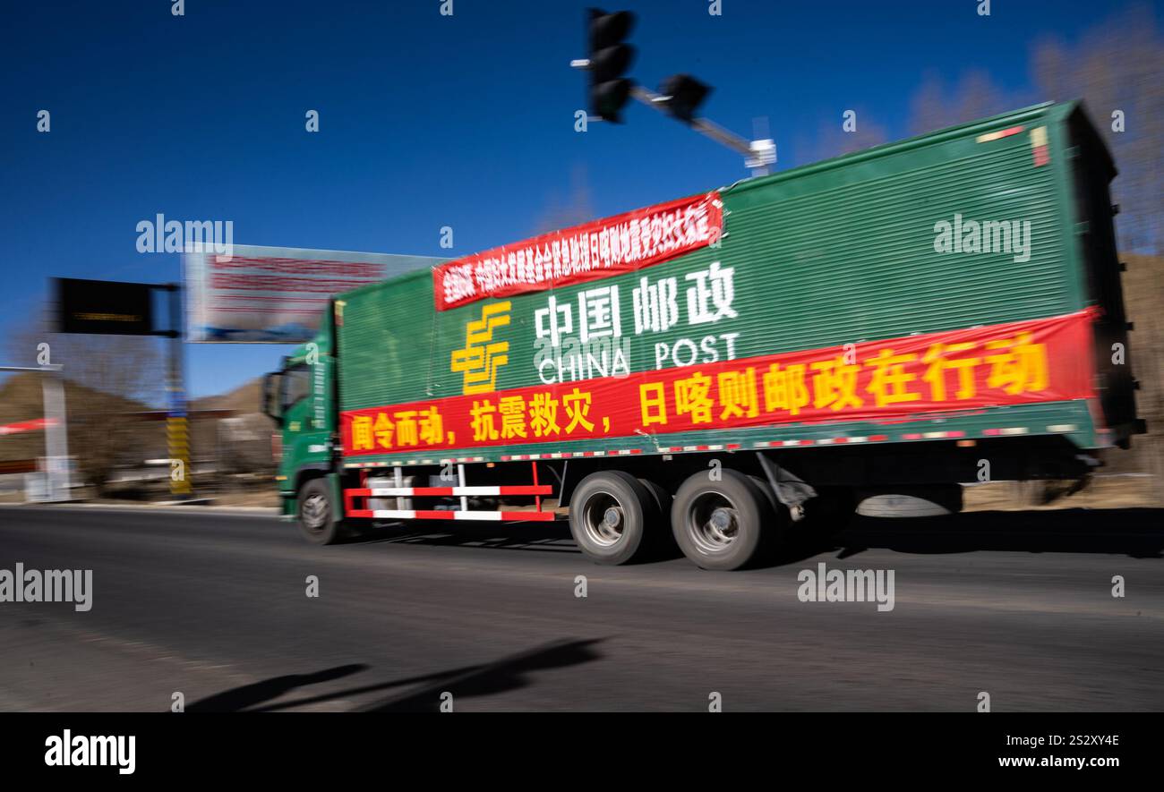 (250108) -- LHASA, Jan. 8, 2025 (Xinhua) -- A truck of China Post loaded with relief supplies drives towards the epicenter of the earthquake on a section of National Highway 318vin Xigaze City, southwest China's Xizang Autonomous Region, Jan. 8, 2025. The strong earthquake that struck around 9 a.m. Tuesday has toppled thousands of rural houses. By Tuesday midnight, a total of 126 people have been confirmed dead and 188 others injured. As the search and rescue efforts went on, 170,000 urgently needed items such as quilts, blankets, cotton coats, stoves and instant noodles were shipped to the d Stock Photo