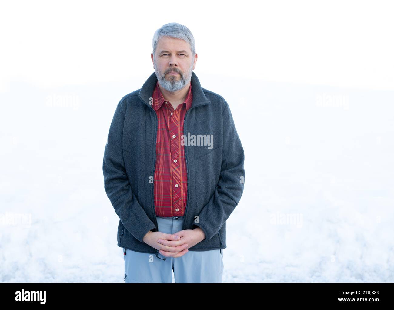 Man, 56 years, grey hair and beard, standing outside in winter with ...