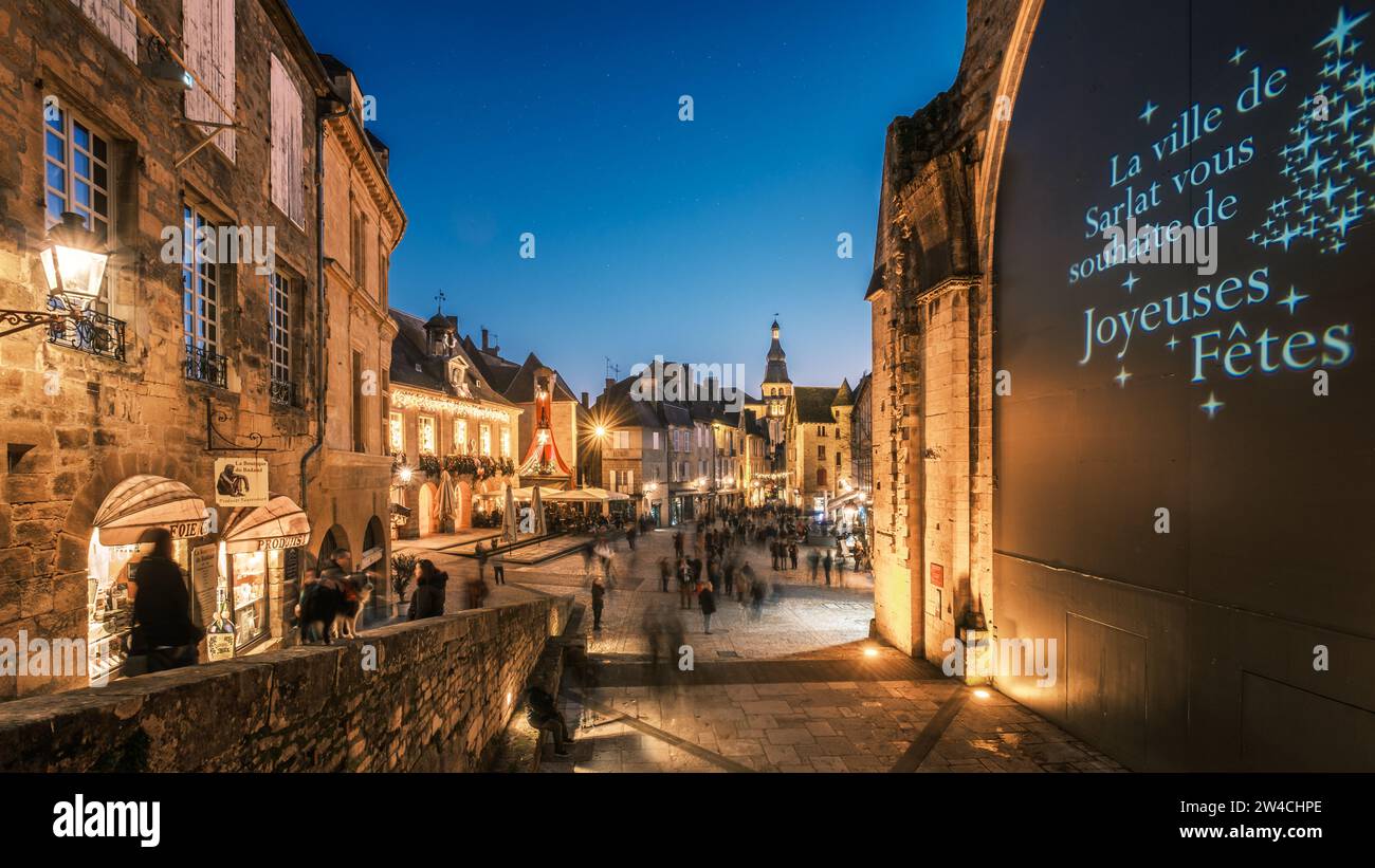 Sarlat-le-Caneda, France - 19th September 2023: Dusk falling over Christmas shoppers in the market square at Sarlat in the Dordogne region of France Stock Photo