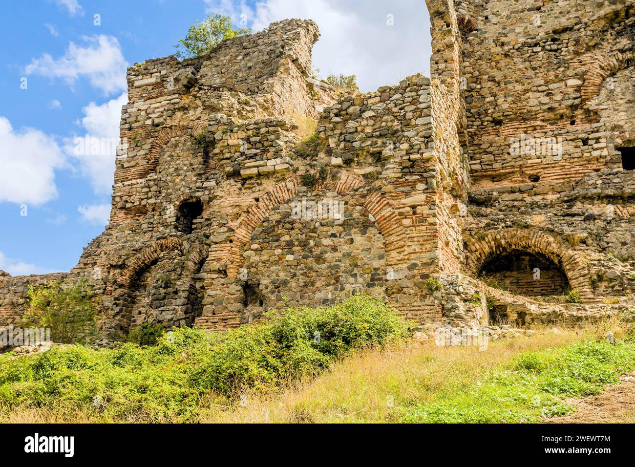 Interior stone and brick wall of castle ruins on hillside under cloudy sky in Turkey Stock Photo