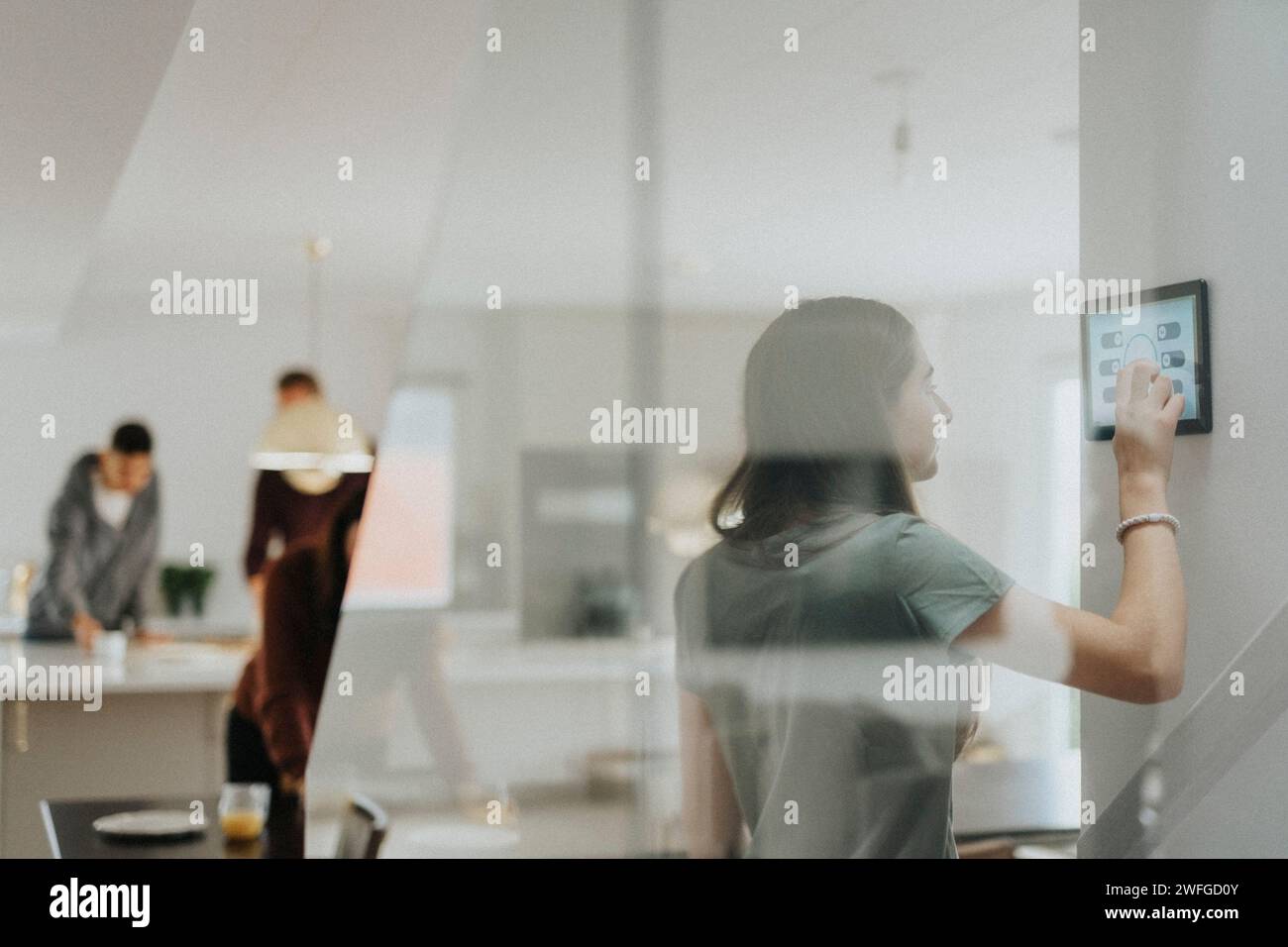 Girl using digital tablet and controlling room temperature at modern home Stock Photo