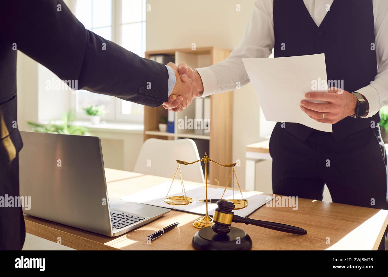 Male lawyer working in office shaking hand with a man client standing at the desk on workplace Stock Photo