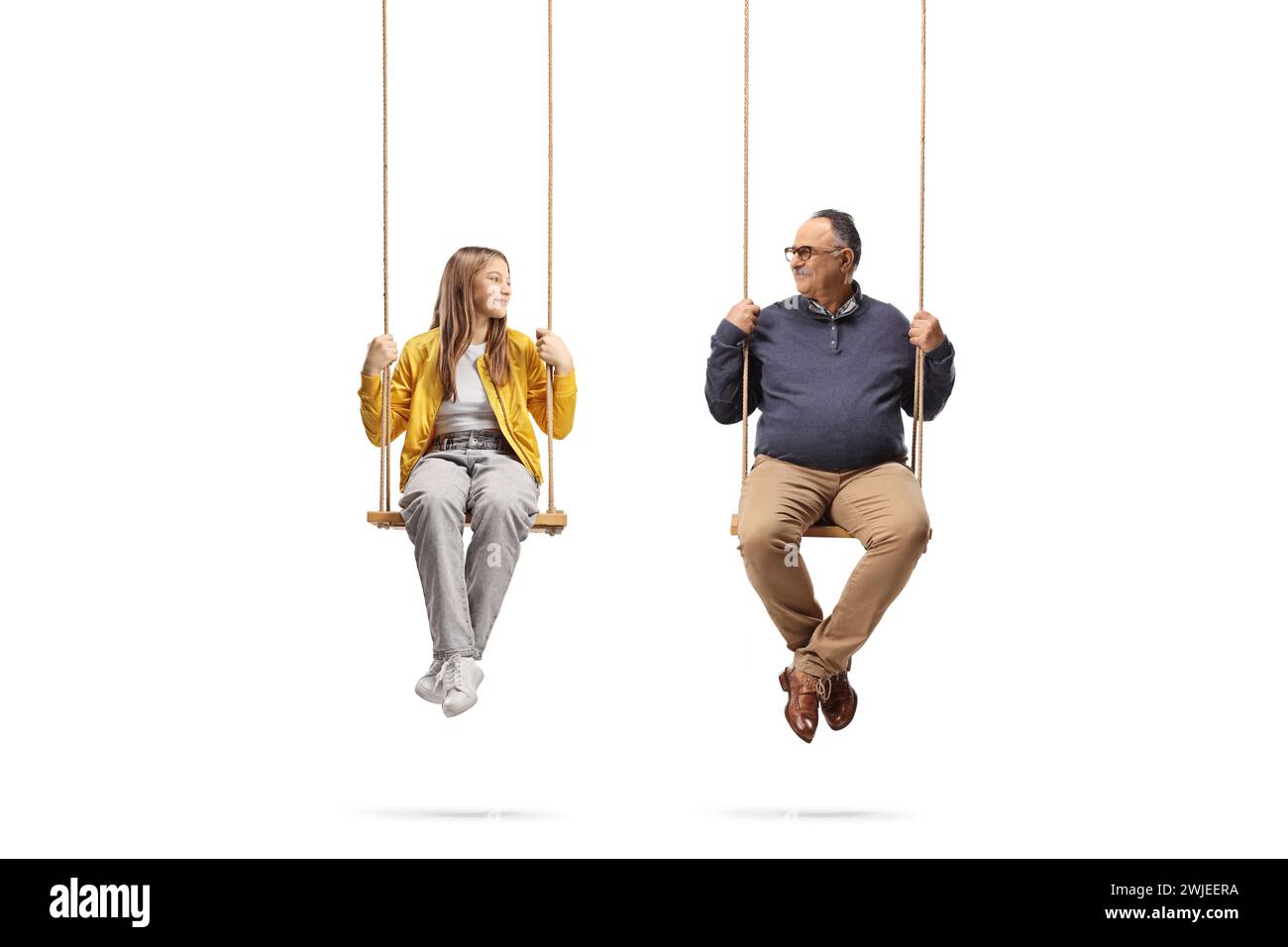 Mature man and a teenage girl sitting on swings and looking at each other isolated on white background Stock Photo