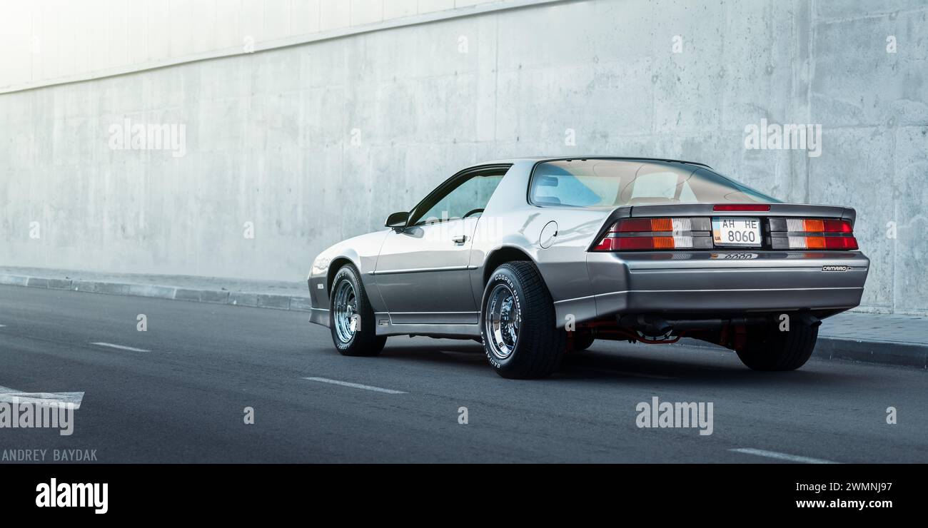 Chevrolet Camaro parked near concrete wall. Third-Generation of pony car Chevy Camaro built in the 1980s. Stock Photo