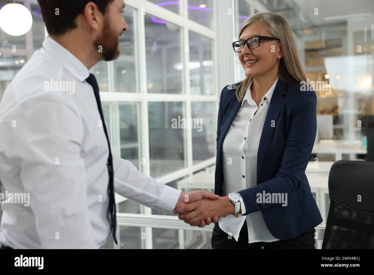 Lawyer shaking hands with client in office Stock Photo