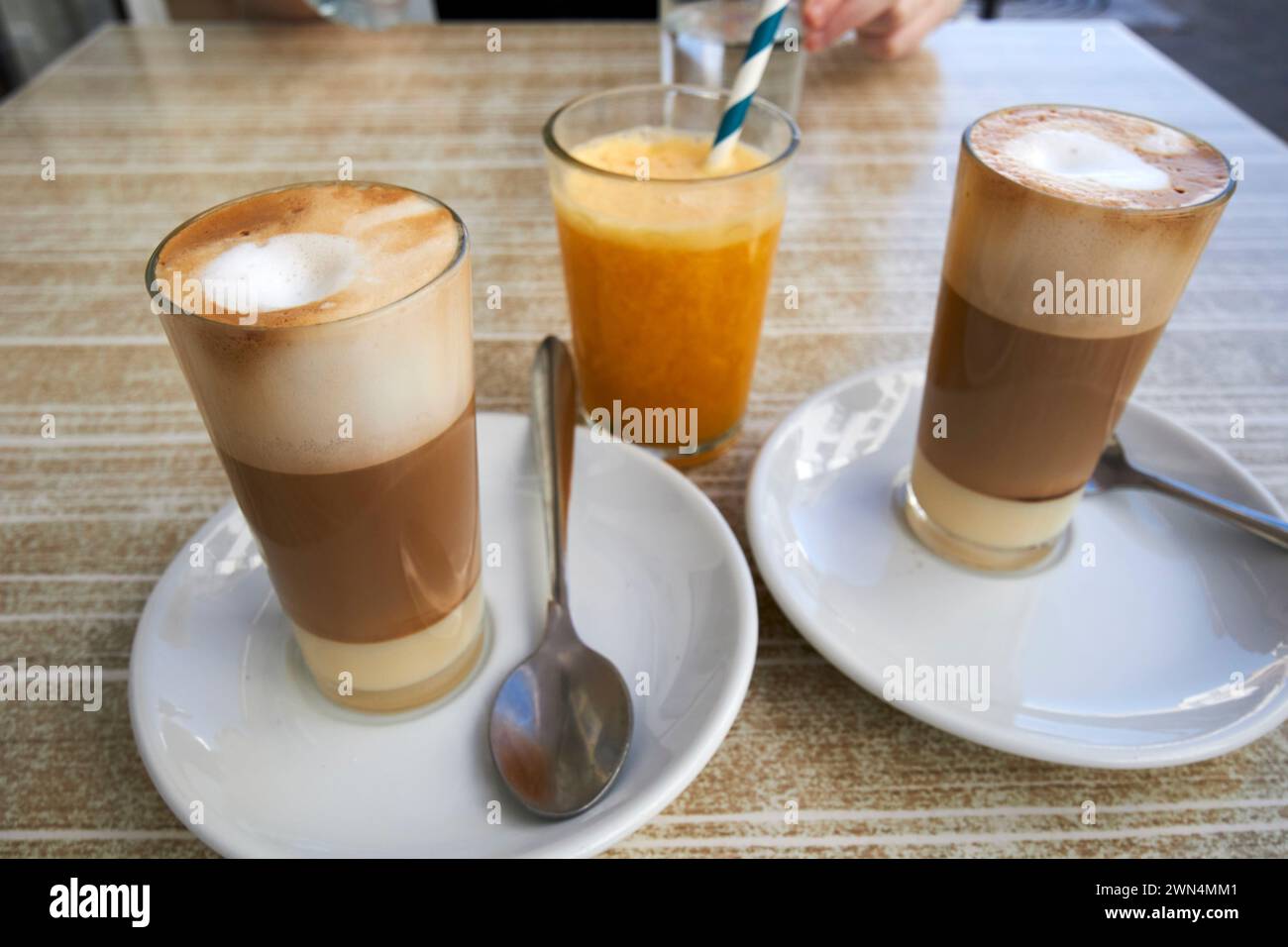 two cafe leche leche or cafe con leche y leche and orange juice in a cafe in Corralejo, fuerteventura, Canary Islands, spain Stock Photo