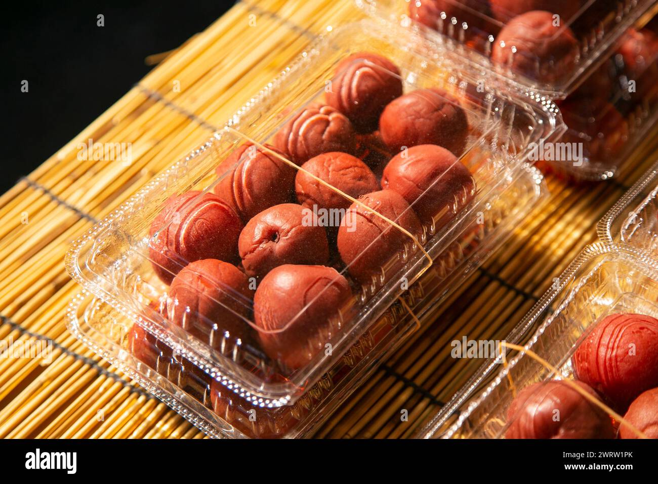 Umeboshi is a traditional Japanese dish, an ume pickle that is dried, salted in barrels, and a weight is placed on top to squeeze out the juice. Stock Photo