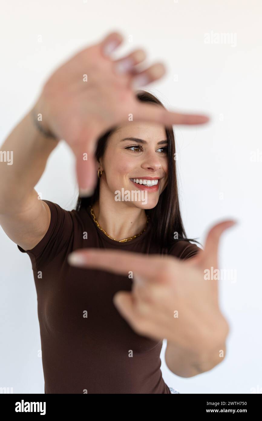 Woman framing face with hands, smiling Stock Photo