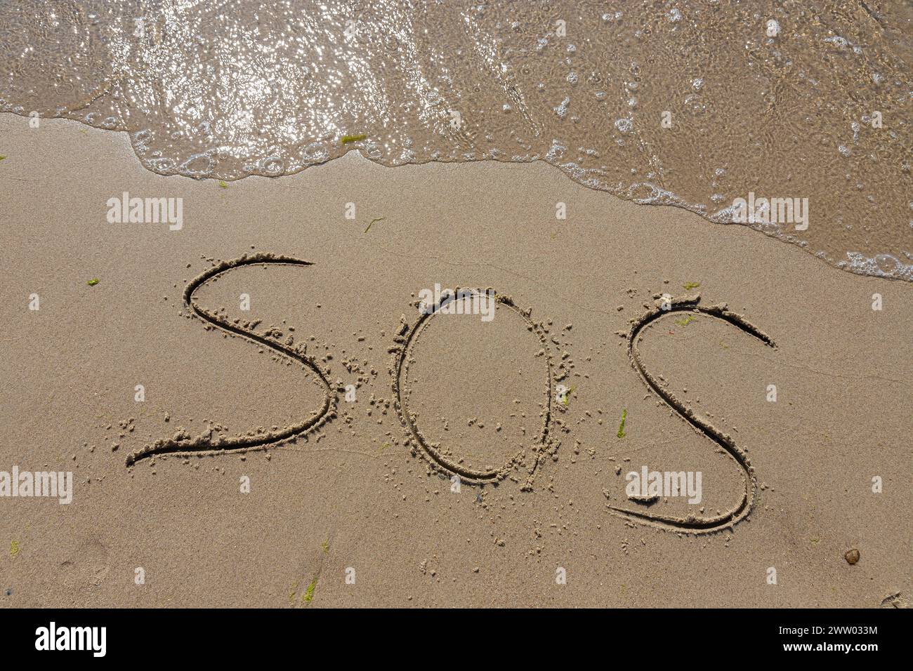 The inscription on the sand at the beach sos. Stock Photo