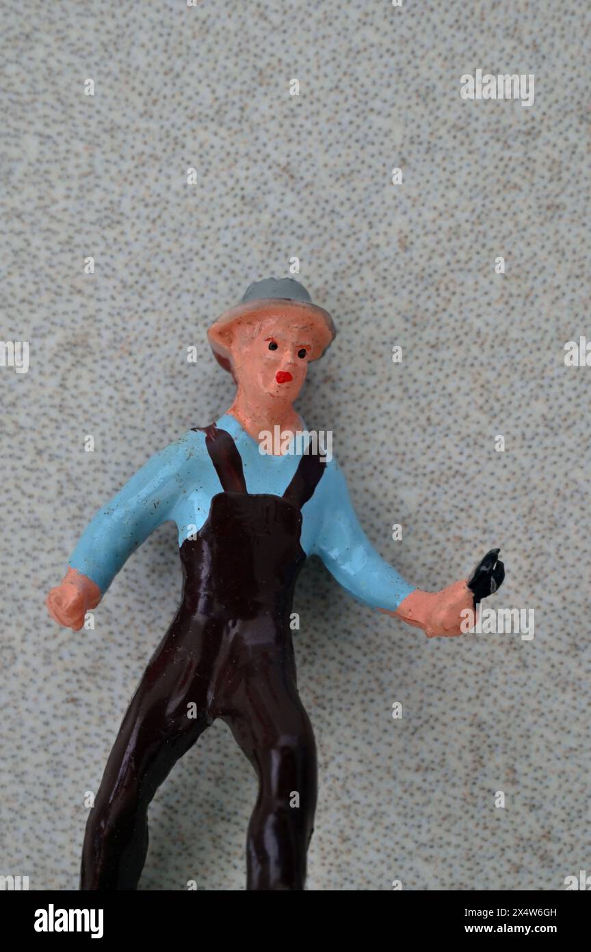 Plastic model of man in overalls holding tool like pincers or wrench Stock Photo