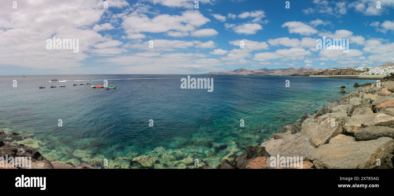 Clear water of Atlantic ocean and seawall at Puerto del Carmen, Lanzarote, Canary Islands (Panorama) Stock Photo